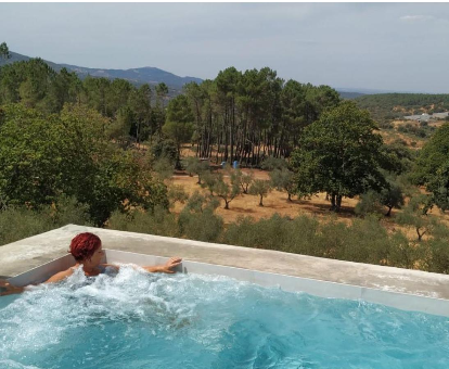 Foto de una señora disfrutando de las vs¡istas de una piscina de hidromasaje de la Casa Rural Madre del Agua. Finca El Robledillo