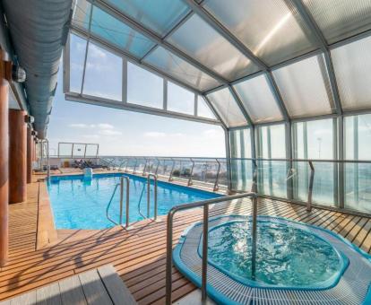 Zona de bienestar con jacuzzi y piscina exterior de este hotel con vistas al mar.