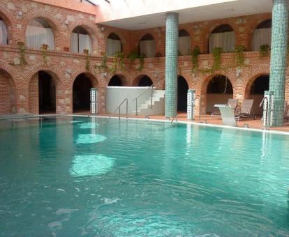 Gran piscina con elementos de hidroterapia del centro de bienestar del hotel.