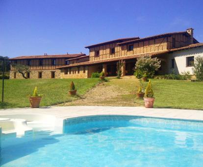 Coqueto hotel rural con amplios jardines y piscina al aire libre.