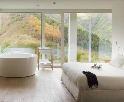 Fabuloso dormitorio de la suite de 2 dormitorios con bañeras circular con chorros cerca de la cama y espectaculares vistas.