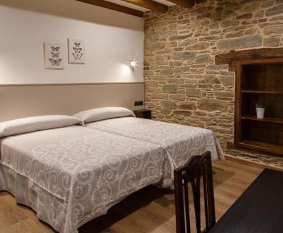 Habitación doble con paredes de piedra a la vida de este coqueto hotel rural.