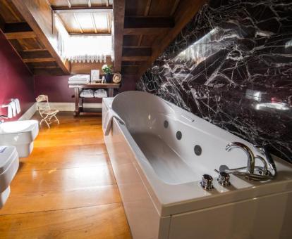 Baño con bañera de hidromasaje privada de la elegante Suite del hotel.
