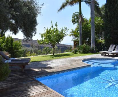 Agradable piscina exterior rodeada de jardines con vistas a la naturaleza de este alojamiento rural.